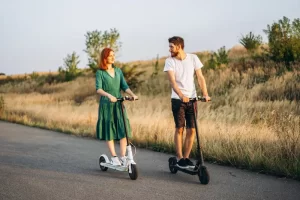 young-couple-vacation-having-fun-driving-electric-scooter-road-countryside (1)