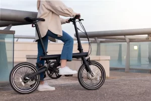 zero-emission-concept-cropped-woman-legs-riding-electric-bicycle-around-city-wearing-casual-outfit